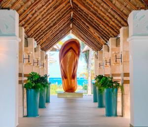 a large sculpture in a hallway with potted plants at Margaritaville Island Reserve Riviera Cancún - An All-Inclusive Experience for All in Puerto Morelos