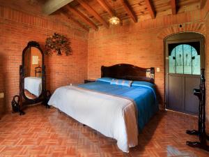 a bedroom with a bed in a brick wall at Hotel Quinta Mirador Zacualli in Bernal