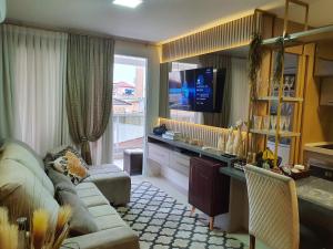 sala de estar con sofá y TV de pantalla plana en Apto de Luxo Mirante Home Club, Magnífico Mar dos Ingleses, en Florianópolis