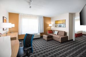 a hotel room with a couch and a chair at TownePlace Suites By Marriott Las Vegas Stadium District in Las Vegas