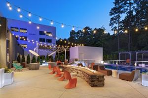 a patio with chairs and a fire pit at night at Aloft Little Rock West in Little Rock