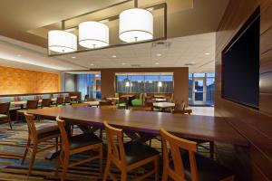 Fairfield Inn & Suites by Marriott Tucumcari في توكومكاري: قاعة اجتماعات مع طاولة وكراسي خشبية كبيرة