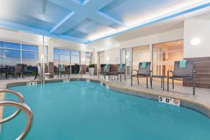 Fairfield Inn & Suites by Marriott Tucumcari في توكومكاري: مسبح في فندق فيه كراسي وطاولات