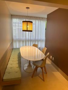 a dining room with a table and chairs at Porto Smeralda Guarajuba C001 in Guarajuba