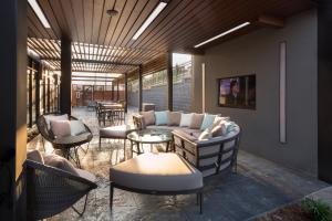 un patio con divano, sedie e tavoli. di Courtyard by Marriott Russellville a Russellville