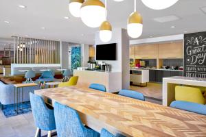 a dining room with a long table and blue chairs at TownePlace Suites by Marriott Asheville West in Asheville