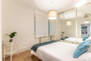 - une chambre avec 2 lits et un miroir dans l'établissement Amplio y Cómodo en Basurto, à Bilbao