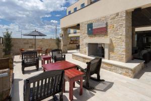 eine Terrasse mit Bänken und Tischen und einem Kamin in der Unterkunft Fairfield Inn & Suites by Marriott Lubbock Southwest in Lubbock
