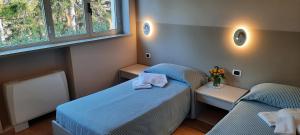 a small room with two beds and two windows at Casa di ALTAVILLA in Alba