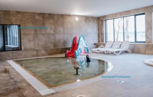 une piscine dans une pièce avec des chaises blanches dans l'établissement Apartament Turkusowy - basen, sauna, klimatyzacja, à Dziwnów