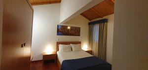 a hotel room with a bed and two lamps at Bungalows - Serra do Gerês in Campo do Gerês