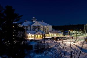 een groot gebouw met 's nachts verlichting in de sneeuw bij Residence Inn by Marriott Gravenhurst Muskoka Wharf in Gravenhurst