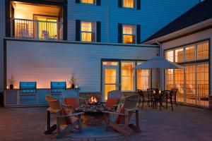 a patio with a table and chairs and an umbrella at Residence Inn by Marriott Gravenhurst Muskoka Wharf in Gravenhurst