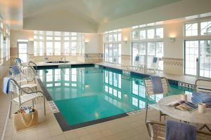 a large swimming pool with chairs and a table in a building at Residence Inn by Marriott Gravenhurst Muskoka Wharf in Gravenhurst