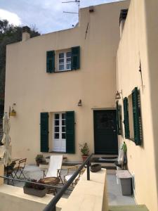 a building with green shutters and a patio at B&B Lacrêma in Finale Ligure
