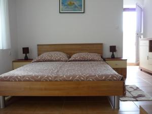a bedroom with a wooden bed with two night stands at Studios Ivana in Umag
