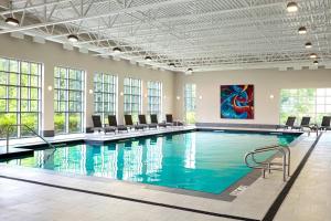 une grande piscine avec des chaises et un tableau mural dans l'établissement The Algonquin Resort St. Andrews by-the-Sea, Autograph Collection, à Saint Andrews