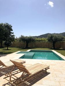 una piscina con 2 sillas de césped y un banco en Jardim do Olival - Casa com piscina en Correlhã