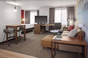 a hotel room with a bed and a living room at Residence Inn by Marriott Tuscaloosa in Tuscaloosa