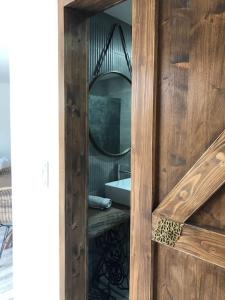 una puerta de madera con espejo y lavabo en Jardim do Olival - Casa com piscina en Correlhã