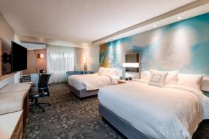 a hotel room with two beds and a flat screen tv at Courtyard by Marriott Tampa Northwest/Veterans Expressway in Tampa