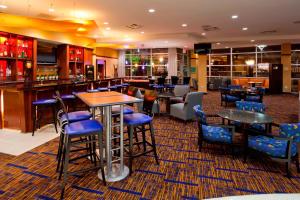 un restaurante con mesas y sillas y un bar en Courtyard Minneapolis Maple Grove Arbor Lakes, en Maple Grove