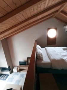 an attic bedroom with two beds and a window at Guesthouse Vasiliki in Steni Dirfyos