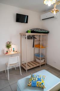 a room with a bed and a table and a tv at La Zagara in Aci Castello