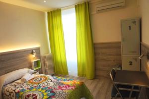 um quarto com uma cama e uma janela com cortinas verdes em MuchoMadrid em Madrid