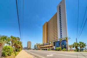a large building on the side of a road with palm trees at Sterling Reef 1407 in Panama City Beach