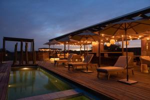 a deck with chairs and a swimming pool at night at Viatura Omún, San Miguel de Allende, All Inclusive in La Venta
