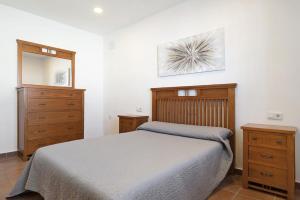 a bedroom with a bed and two dressers and a mirror at Vivienda Rural El chiclanero in Conil de la Frontera