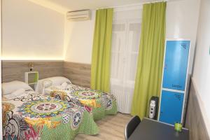 een hotelkamer met 2 bedden en een laptop bij MuchoMadrid in Madrid