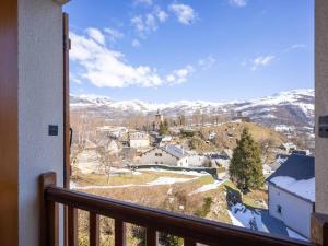 a view from a balcony of a town with snow covered mountains at Maison Génos-Val Louron, 5 pièces, 10 personnes - FR-1-695-26 in Génos