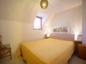 a bedroom with a yellow bed and a window at Appartement 8 personnes à Génos - Wifi, près du lac - FR-1-695-22 in Génos