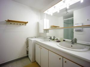 a white bathroom with two sinks and a mirror at Appartement 8 personnes à Génos - Wifi, près du lac - FR-1-695-22 in Génos +8 photos