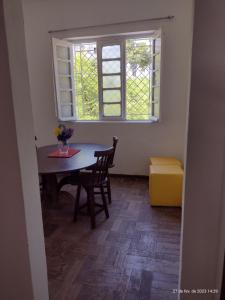 a dining room with a table and chairs and a window at Apt's Sitio Do Carmo in Olinda