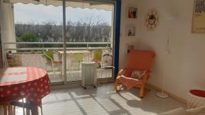 een kamer met een balkon met een tafel en een radiator bij appartement vue mer résidence les terrasses de la mer in La Grande-Motte