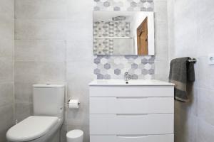 a bathroom with a toilet and a sink and a mirror at Vivienda Rural El chiclanero in Conil de la Frontera +17 photos