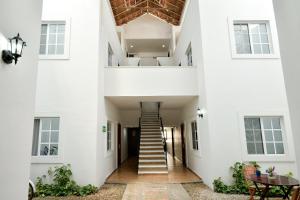 un pasillo de una casa blanca con escaleras y una mesa en International House en Playa del Carmen