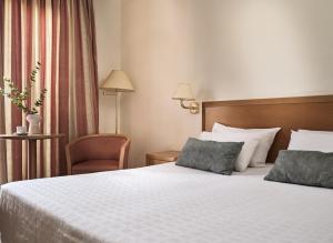a hotel room with a bed and a chair at Strada Marina Hotel in Zakynthos