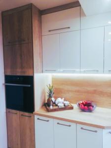 ブワディスワボボにあるApartament 24のキッチン(白いキャビネット付)、カウンターにフルーツを用意しています。 +8枚の写真