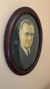 a framed picture of a man in a suit and tie at A Showplace of Greendale History on Apple Court in Greendale