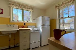 a kitchen with a white refrigerator and a sink at A Showplace of Greendale History on Apple Court in Greendale