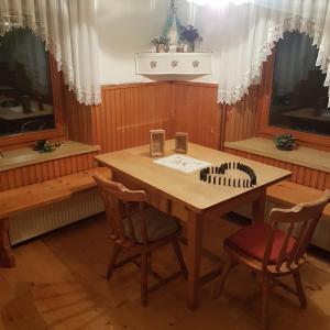 Železniki的住宿－Miklavževa hiša with a bread oven，一间带木桌和两把椅子的用餐室