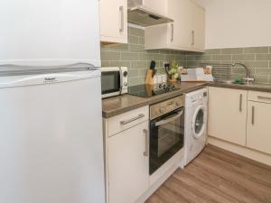 a kitchen with a white refrigerator and a dishwasher at Cwtch Carys in Cardigan