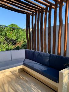 - un canapé bleu installé au-dessus d'une terrasse couverte dans l'établissement Luana Suites- Suite Aruma, à Zihuatanejo