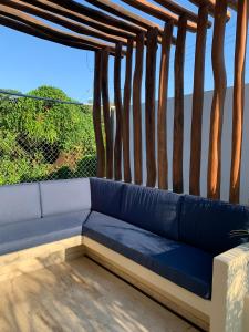 un divano blu seduto sopra un portico di Luana Suites- Suite Aruma a Zihuatanejo