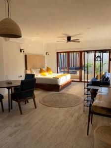 una camera da letto con un letto, un tavolo e delle sedie di Luana Suites- Suite Aruma a Zihuatanejo