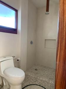 La salle de bains est pourvue de toilettes et d'une fenêtre. dans l'établissement Luana Suites- Suite Aruma, à Zihuatanejo
